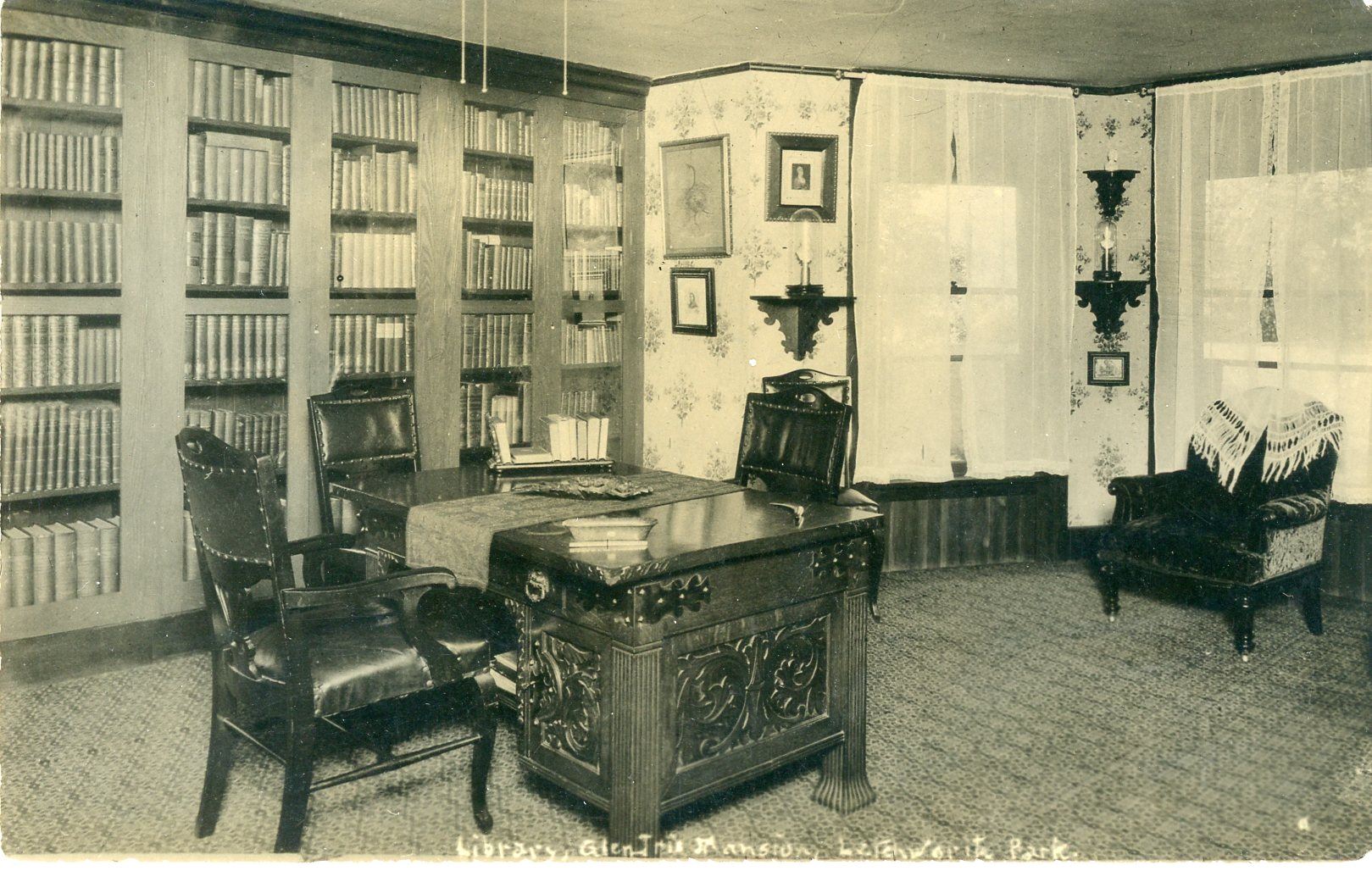 Image of library at Glen Iris Mansion, Letchworth State Park, with tall shelves of books and a desk